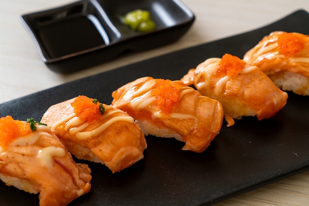 grilled salmon sushi on black plate