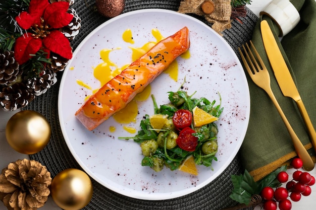 オレンジソースとサラダのグリルサーモンと食べ物のクリスマステーブル