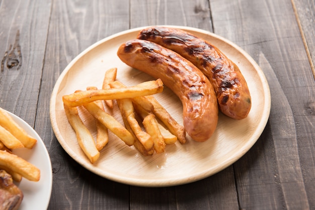 grilled sausage and french fries on wood