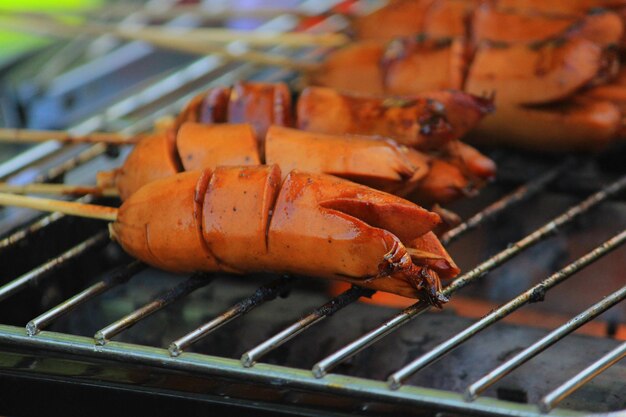 grilled sausage or sosis panggang on grill in the street food selective focus