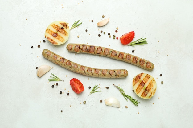 Grilled sausage and spices on white surface