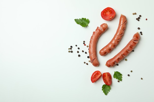 Grilled sausage and spices on white surface