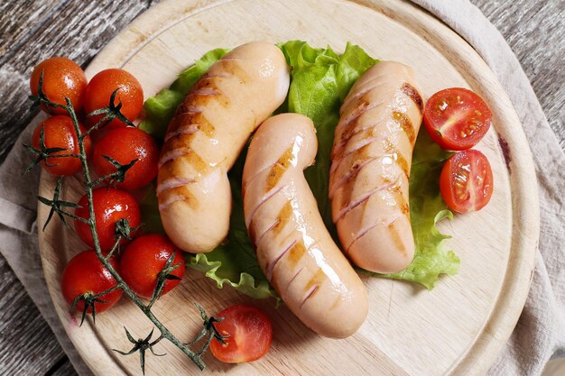 Photo grilled sausage with cherry tomatoes and salad