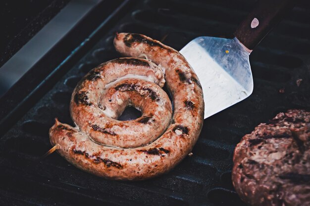 Foto salsiccia alla griglia con rosmarino fresco su piatto barbecue caldo