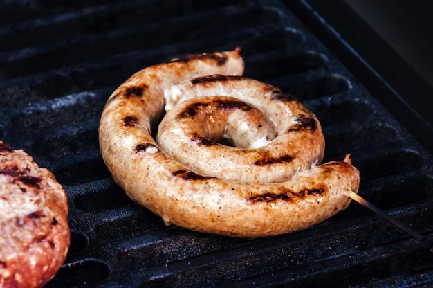 Grilled sausage with fresh rosemary on hot barbecue dish