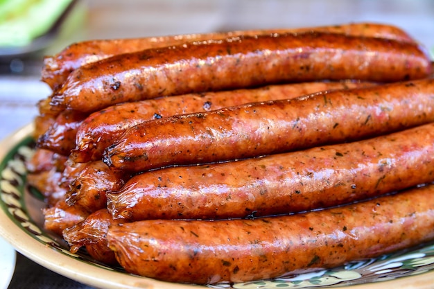 Grilled sausages are appetizingly laid out on a plate with a\
neat slide natural homemade sausages