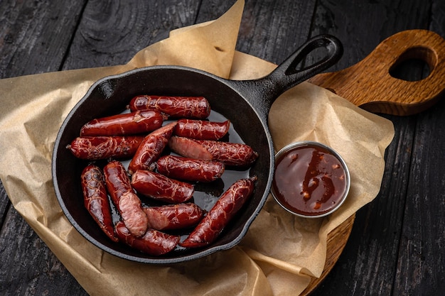 grilled sausages in a pan on a black background