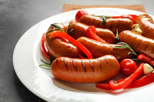 Grilled sausages served with garlic and pepper on plate