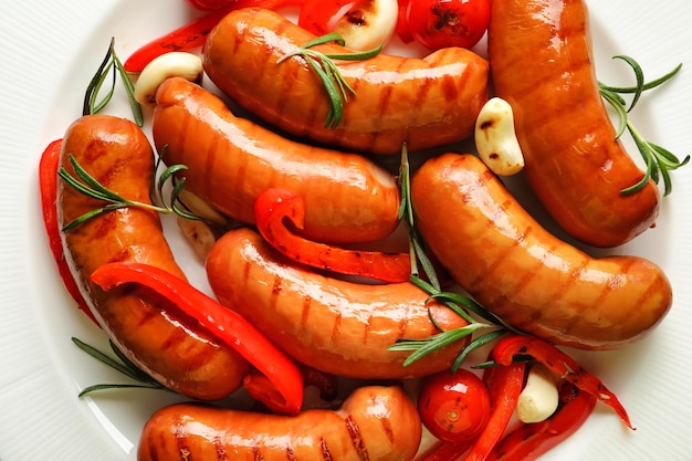 Grilled sausages served with garlic and pepper on plate