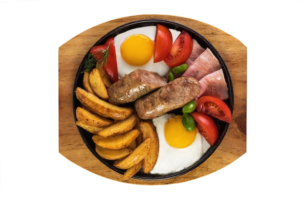 Grilled sausages with bacon and scrambled eggs and spicy rustic potatoes. Isolated