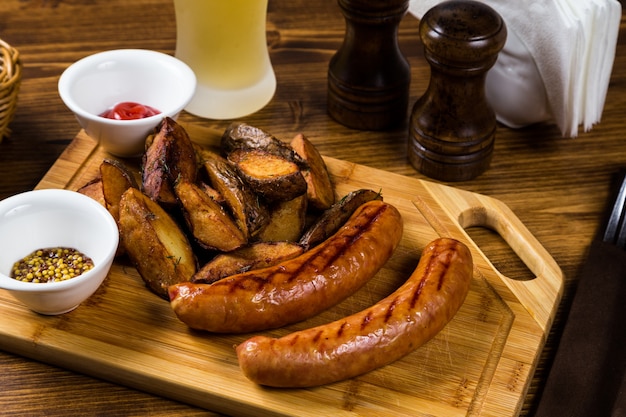 Grilled sausages with roast potato with spices