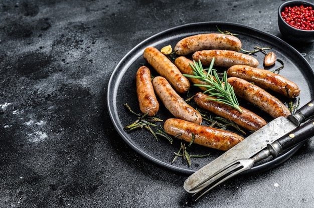Photo grilled sausages with rosemary herbs, beef and pork meat