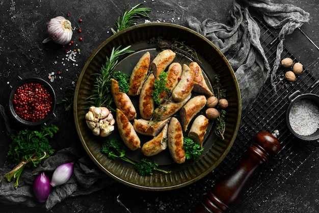 Grilled sausages with rosemary and spices Barbecue On a black stone background