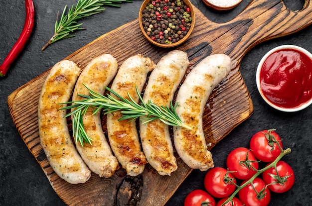 grilled sausages with spices on a stone table