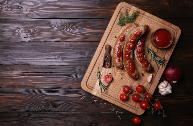 Grilled sausages on a wooden background