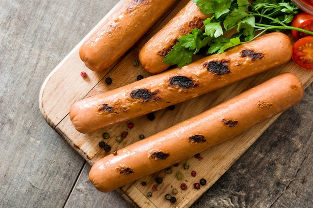 Grilled sausages on wooden table