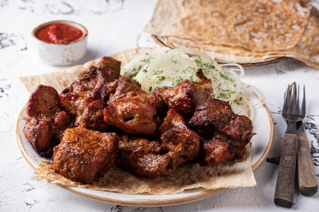 Grilled shish kebab on a plate serbed  fork and knife