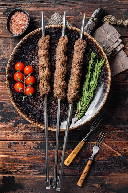 Grilled Shish kebab on skewers from minced lamb beef meat, Lula kebab. Wooden background. Top view.