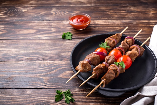 Grilled shish kebab skewers with tomatoes