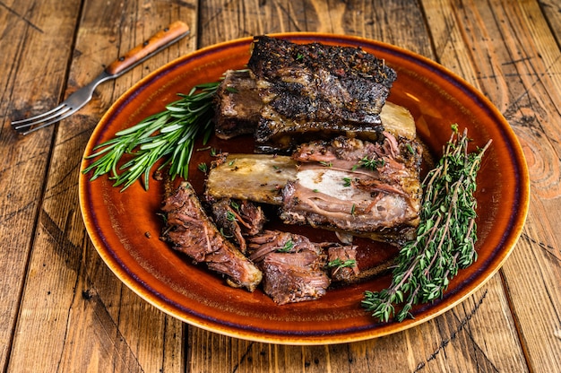 Grilled short beef ribs with thyme on a rustic plate