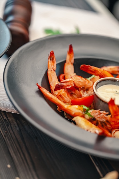 Grilled shrimp salad with arugula and different vegetables