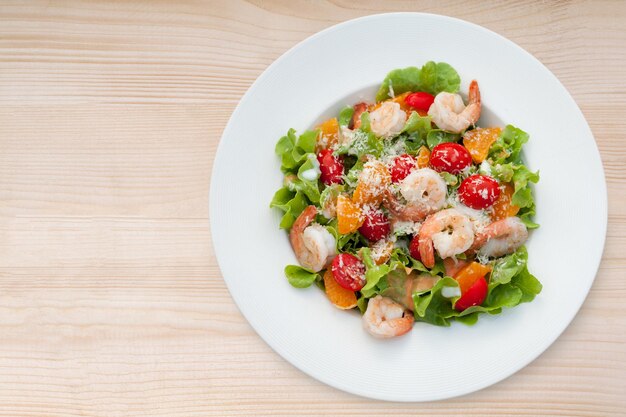 Grilled shrimp salad on wood table Top view