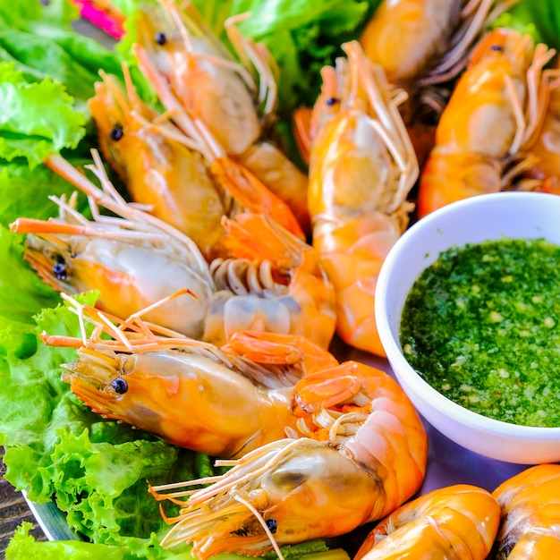 Grilled shrimp on white plate with the materials of spicy sauce on the wooden background