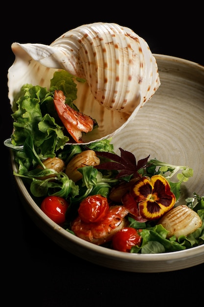 Grilled shrimps and vegetable salad on white plate