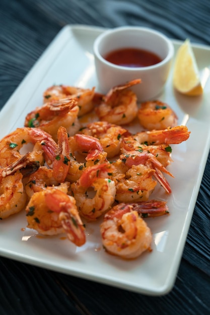 Grilled shrimps with lemon and sauce on a plate