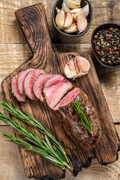 Bistecca di carne di filetto di agnello affettata alla griglia su un tagliere