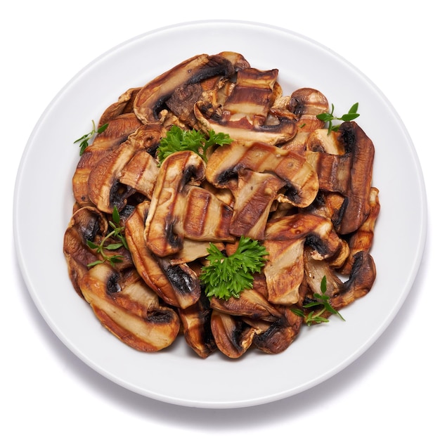 Grilled Slices of champignon mushrooms with stripes from a grill in ceramic plate isolated on white background