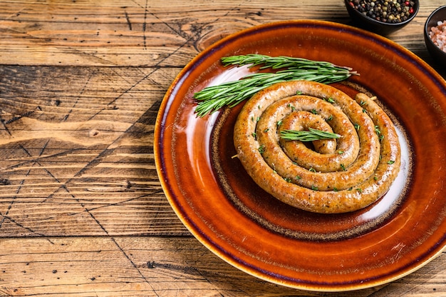 Grilled spiral sausage from pork and beef meat on a rustic plate