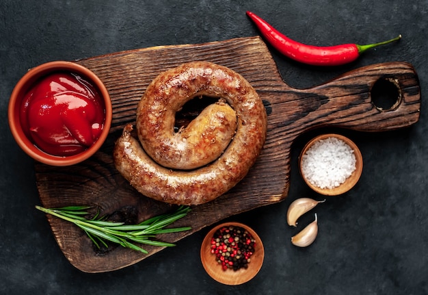 Grilled spiral sausage with spices on a cutting board