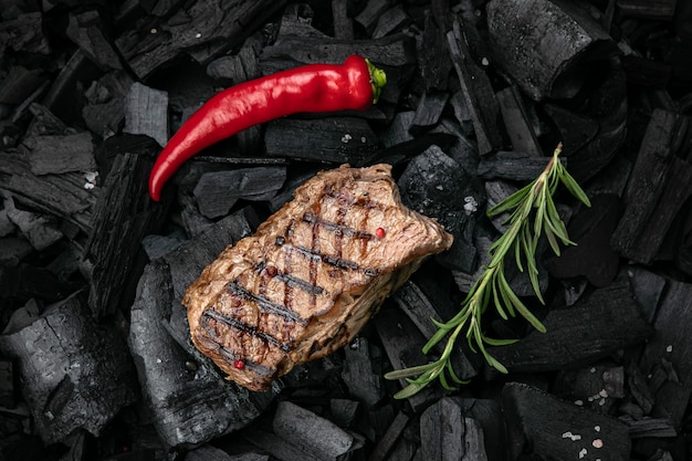 grilled steak on a background of black charcoal