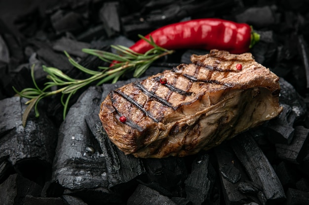 grilled steak on a background of black charcoal