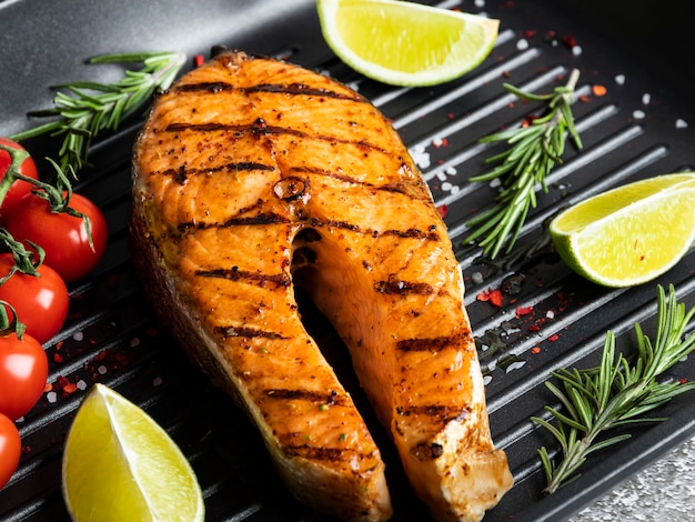 Photo grilled steak fish salmon trout in a grill pan spicy tomato close up top view