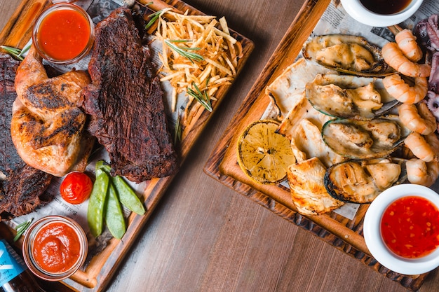 Grilled steak served with vegetables and herbs decorated with napkin over rustic wooden board