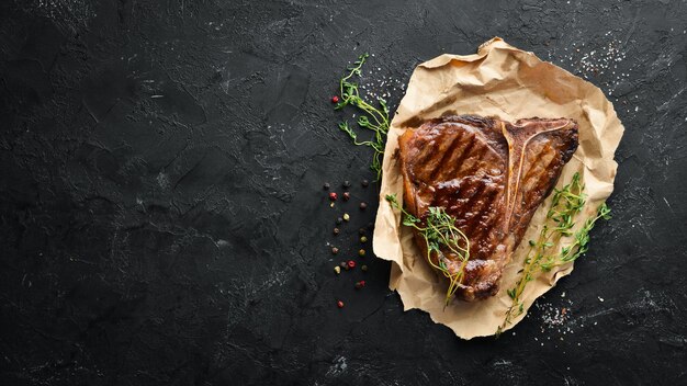 Grilled Steak on a stone table. Top view. Free space for text.