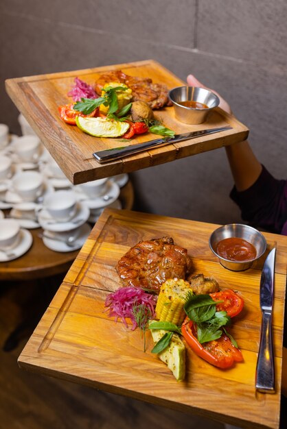 Grilled Steak Striploin and Pepper sauce on cutting board on dark wooden background.