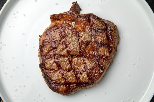 Photo grilled steak on a white round plate