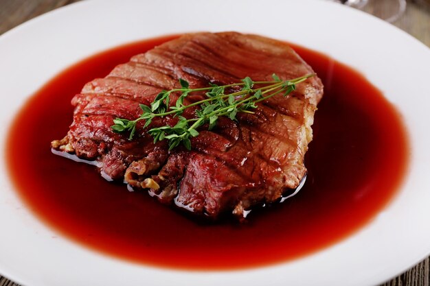 Grilled steak in wine sauce on plate close up