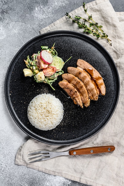 Grilled steak with chicken breast, garnished with rice. Top view