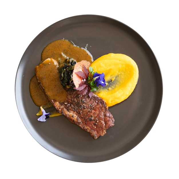 Photo grilled steak with mashed potatoes and herbs isolated over white background