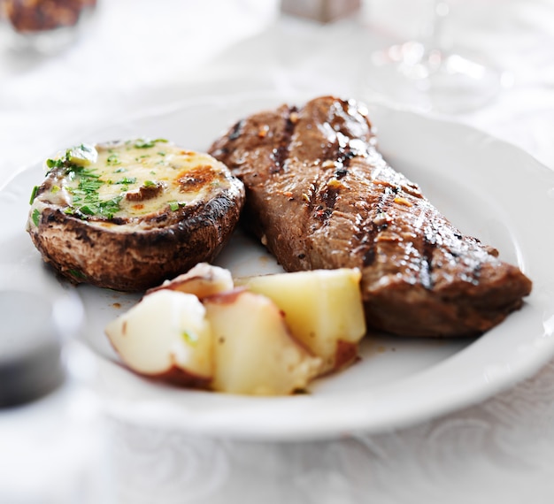 Grilled steak with potatoes and stuffed mushroom