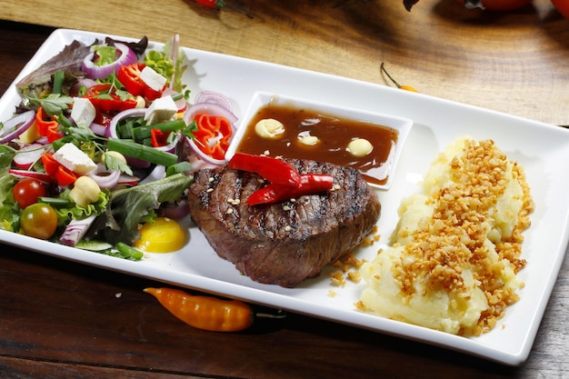 grilled steak with salad and potato