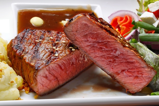 grilled steak with salad and potato