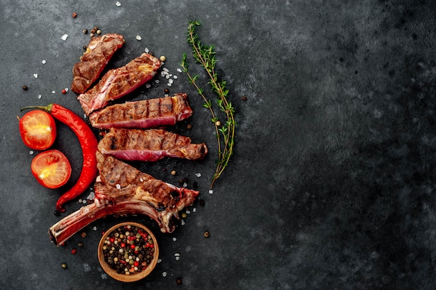 grilled steak with spices, thyme on a stone background. with copy space for your text