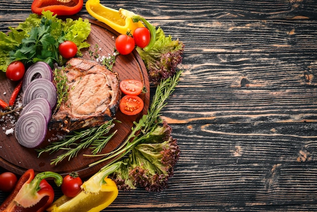 Grilled Steak with Vegetables Pork veal meat On a wooden background Top view Free space for text