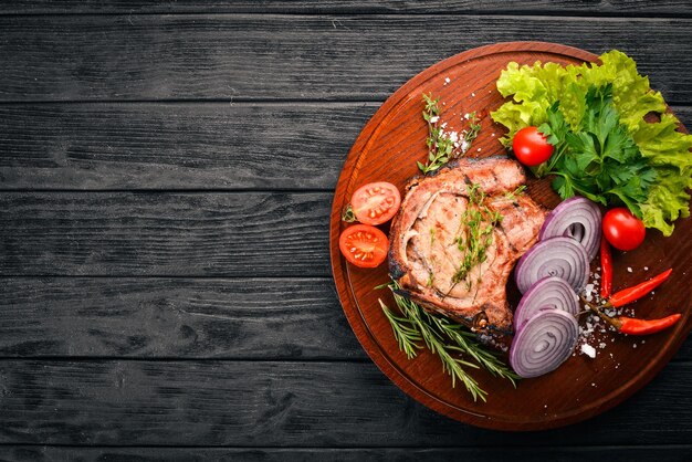 Grilled Steak with Vegetables Pork veal meat On a wooden background Top view Free space for text