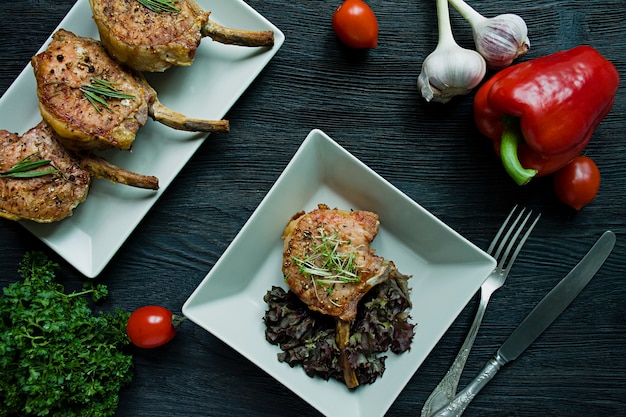 Photo grilled steaks from pork ribs with spices and herbs.